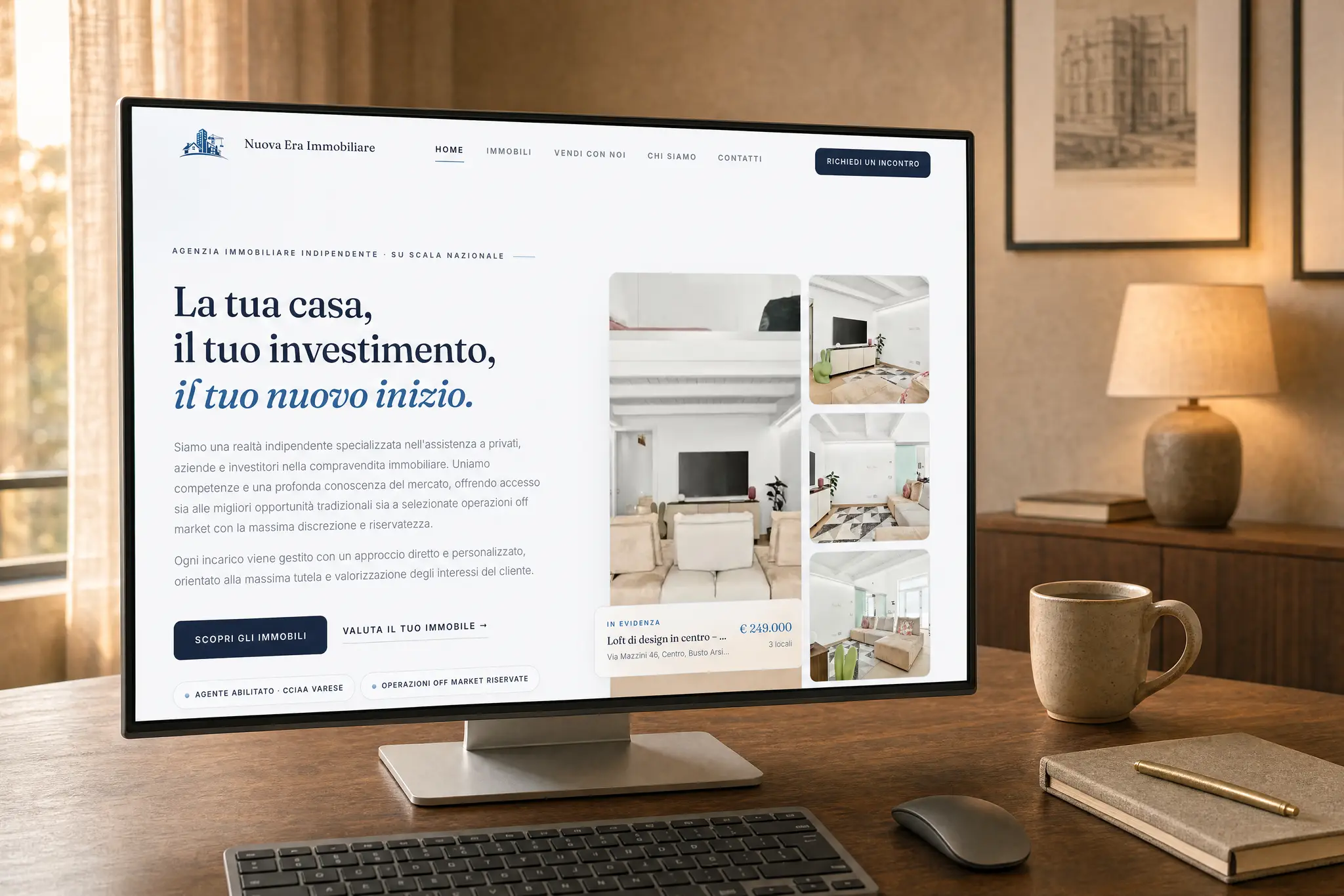 Il sito di Nuova Era Immobiliare su un monitor da scrivania con tastiera e mouse, inquadrato sulla prima schermata: «La tua casa, il tuo investimento, il tuo nuovo inizio», gli immobili in evidenza col prezzo e i tasti per scoprirli o far valutare il proprio.
